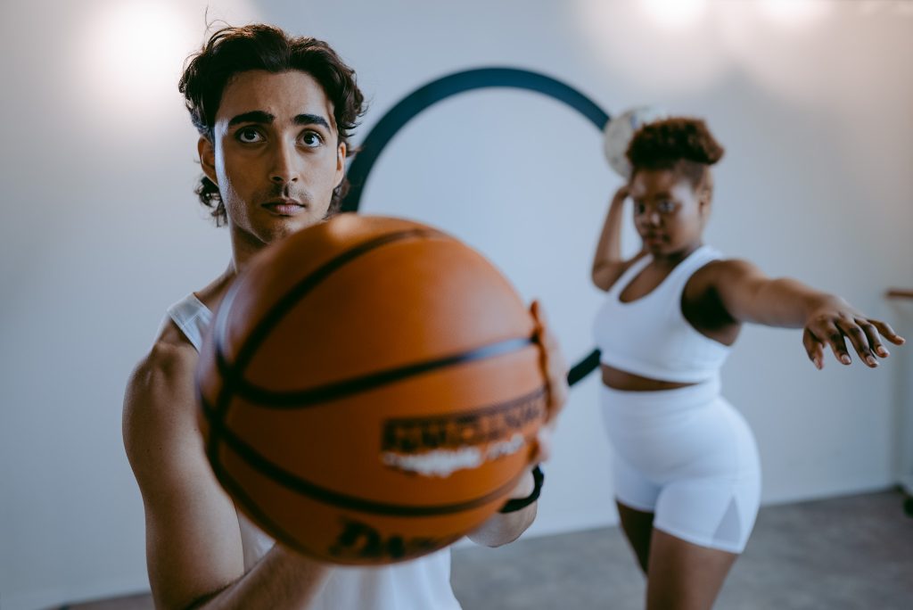 Man and woman exercising with a football to improve strength and fitness for Type 2 Diabetes management.