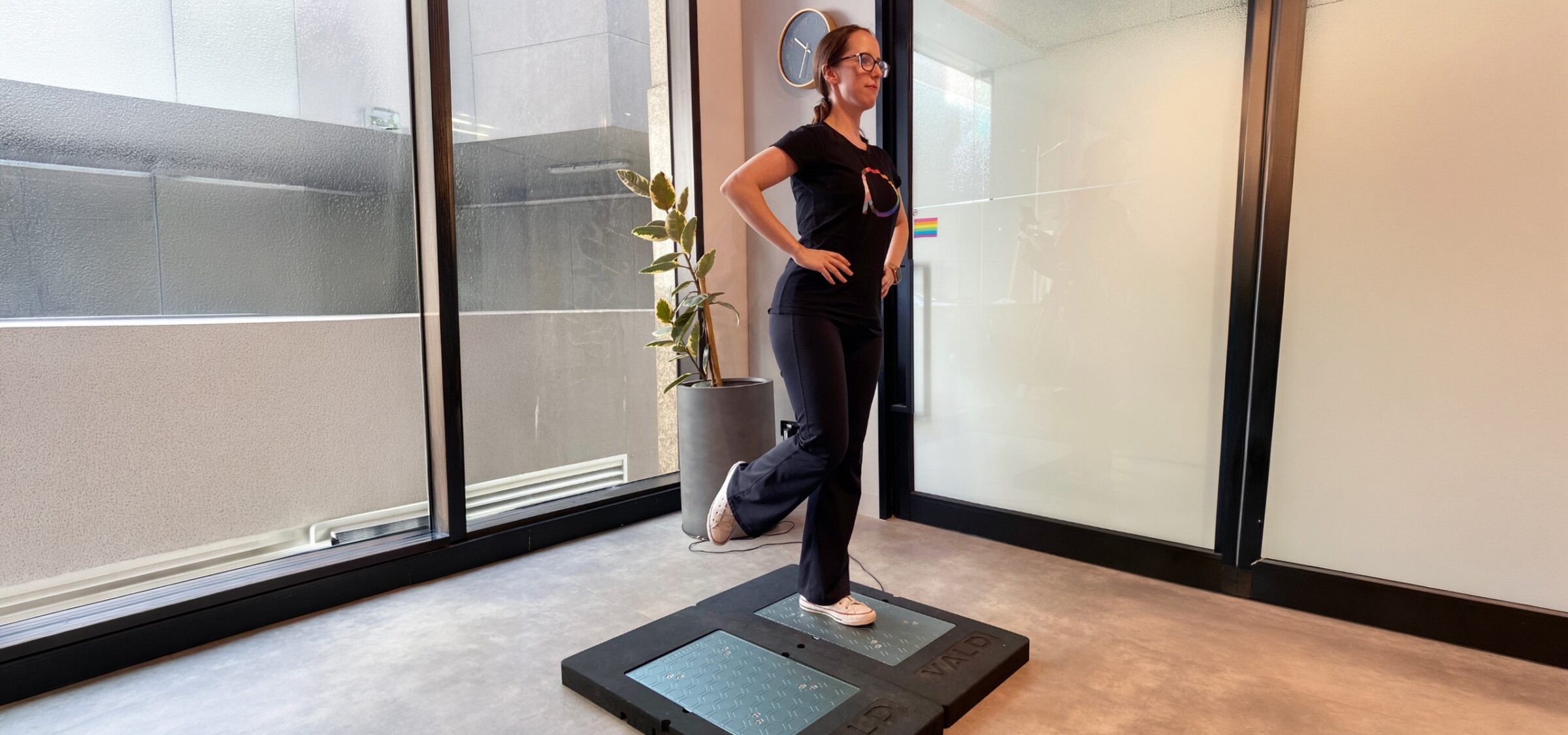Woman performing a single-leg balance assessment on a VALD platform.